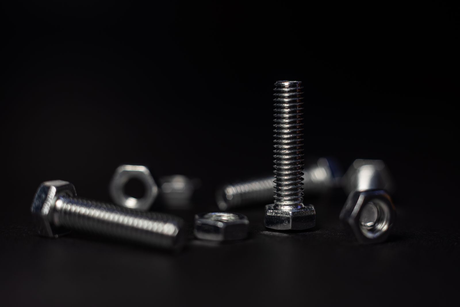 ARTIMO precision fasteners arranged on a dark engineering bench