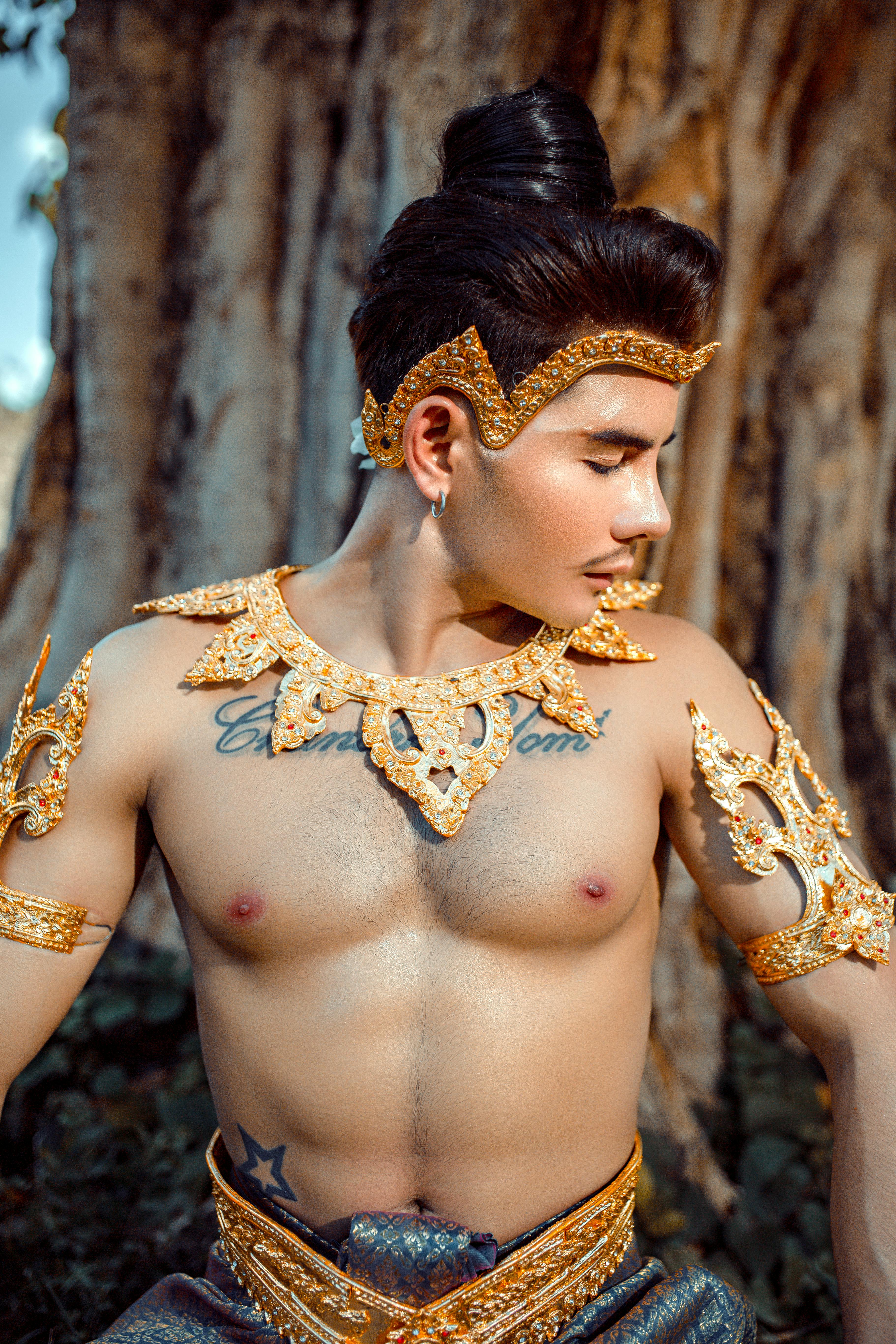 Free Man in traditional attire with ornate jewelry, posing outdoors. Stock Photo