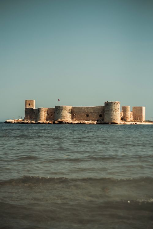 Free A picturesque view of Maidens Castle in Turkey, surrounded by the Mediterranean Sea under a clear sky. Stock Photo