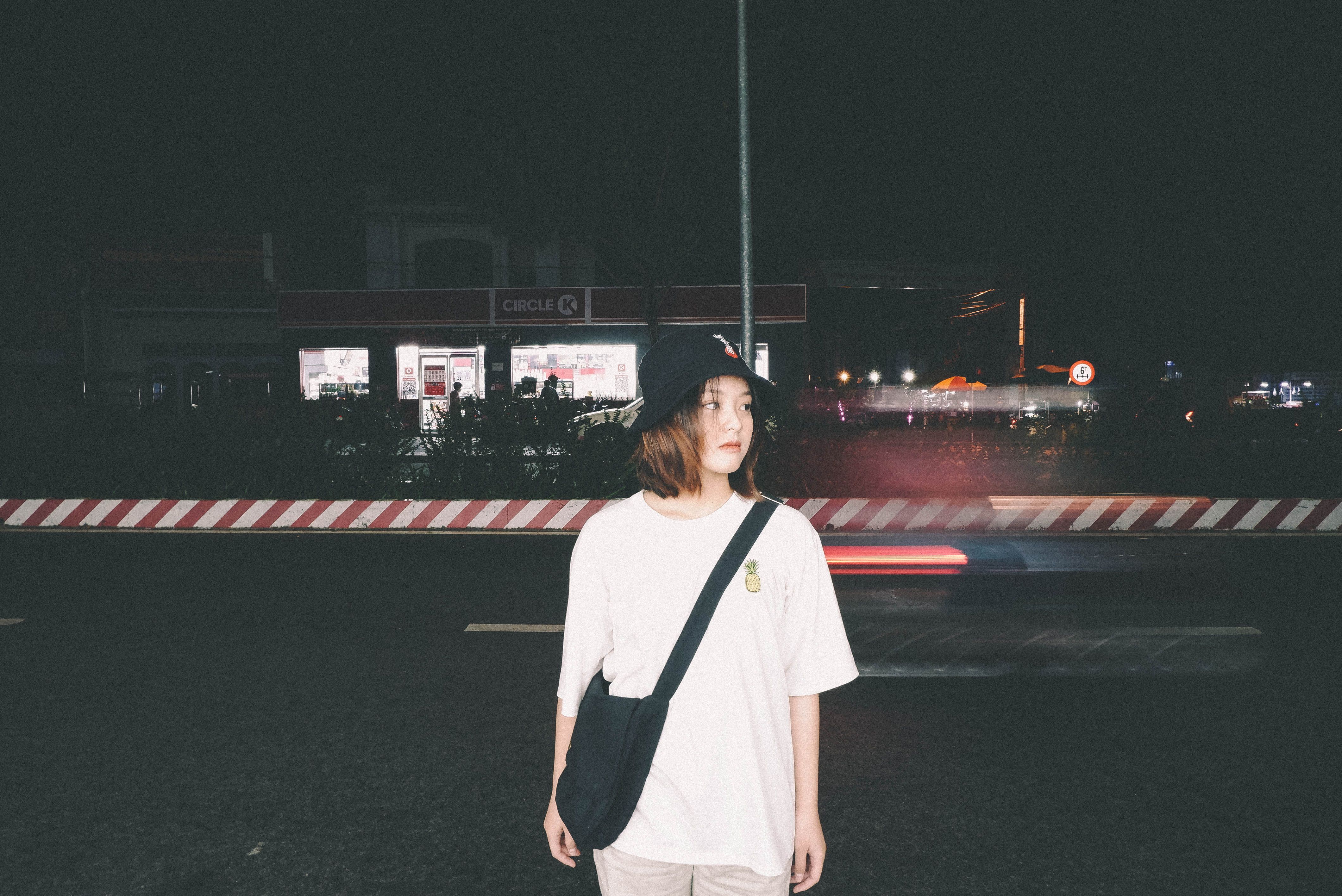 Casual young woman at night in Ho Chi Minh City streets. Nightlife and urban style vibes.