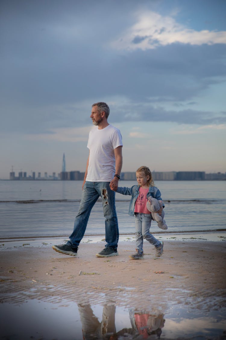 Daughter And Father Walking On Beach