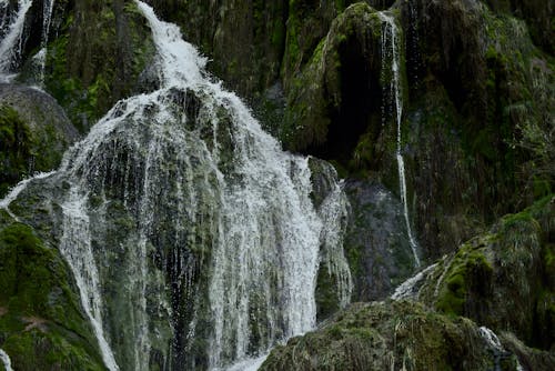 A Waterfall on a Rocky Cliff Covered in Moss