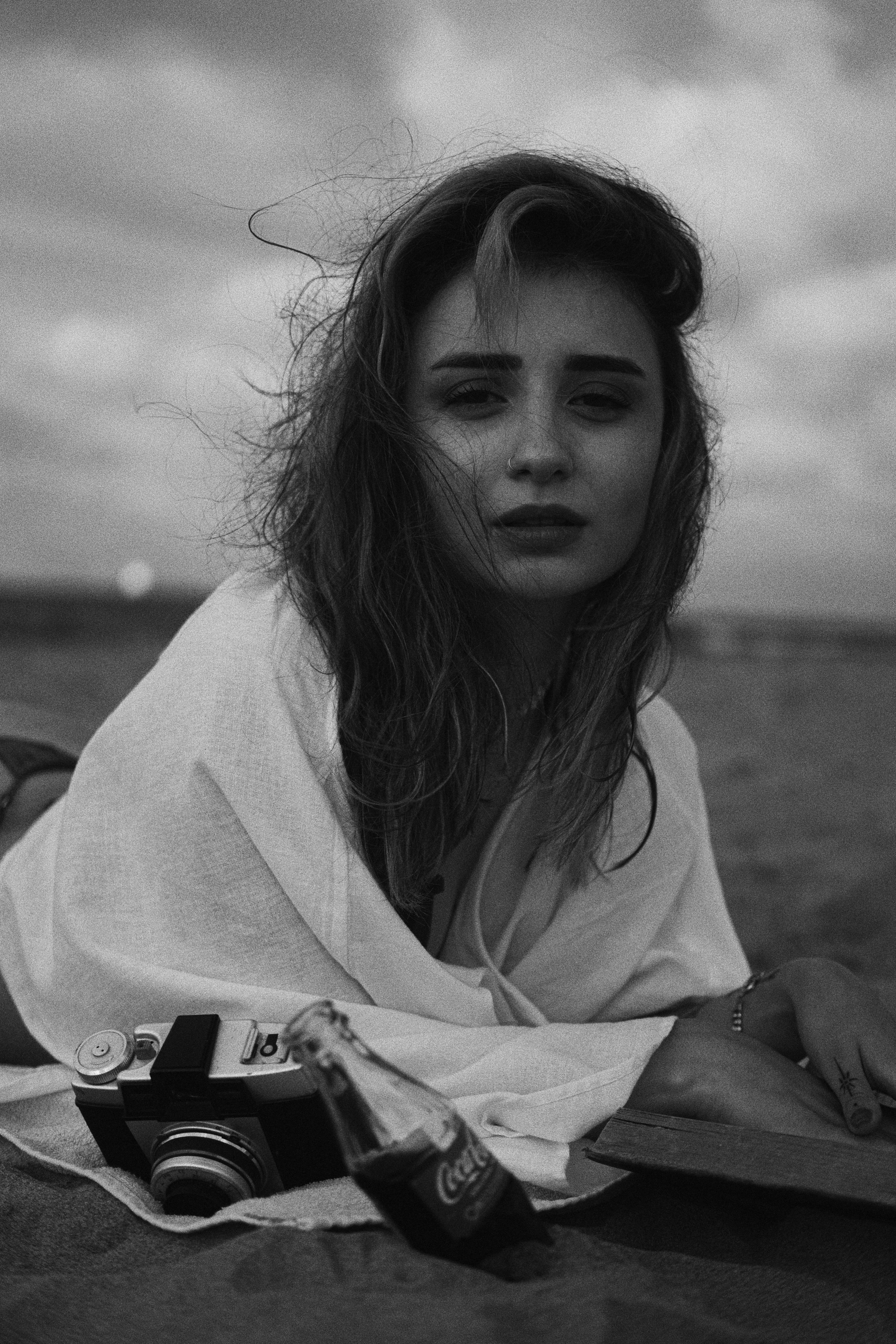 Woman Lying Down with Cola and Camera on Beach · Free Stock Photo