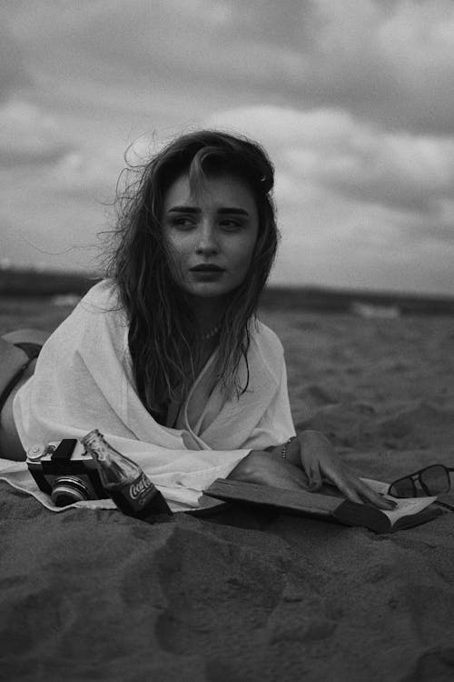 Free Young Woman Reading a Book on the Beach Stock Photo