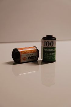 Two photographic film rolls on a white background, showcasing vintage analog photography equipment.