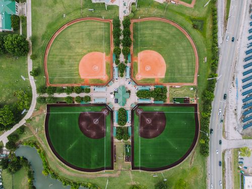 Free Drone shot of four baseball fields in Chattanooga, TN, highlighting green fields and urban surroundings. Stock Photo