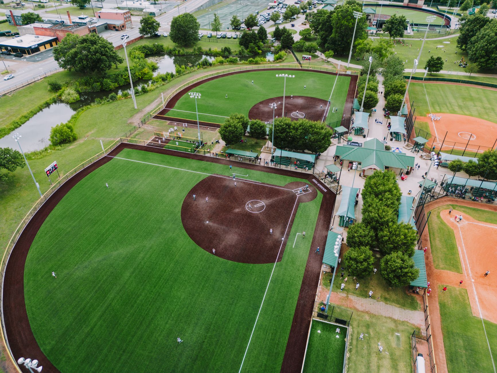 A high-angle aerial shot of baseball fields in Chattanooga, showcasing sports activities and lush greenery.