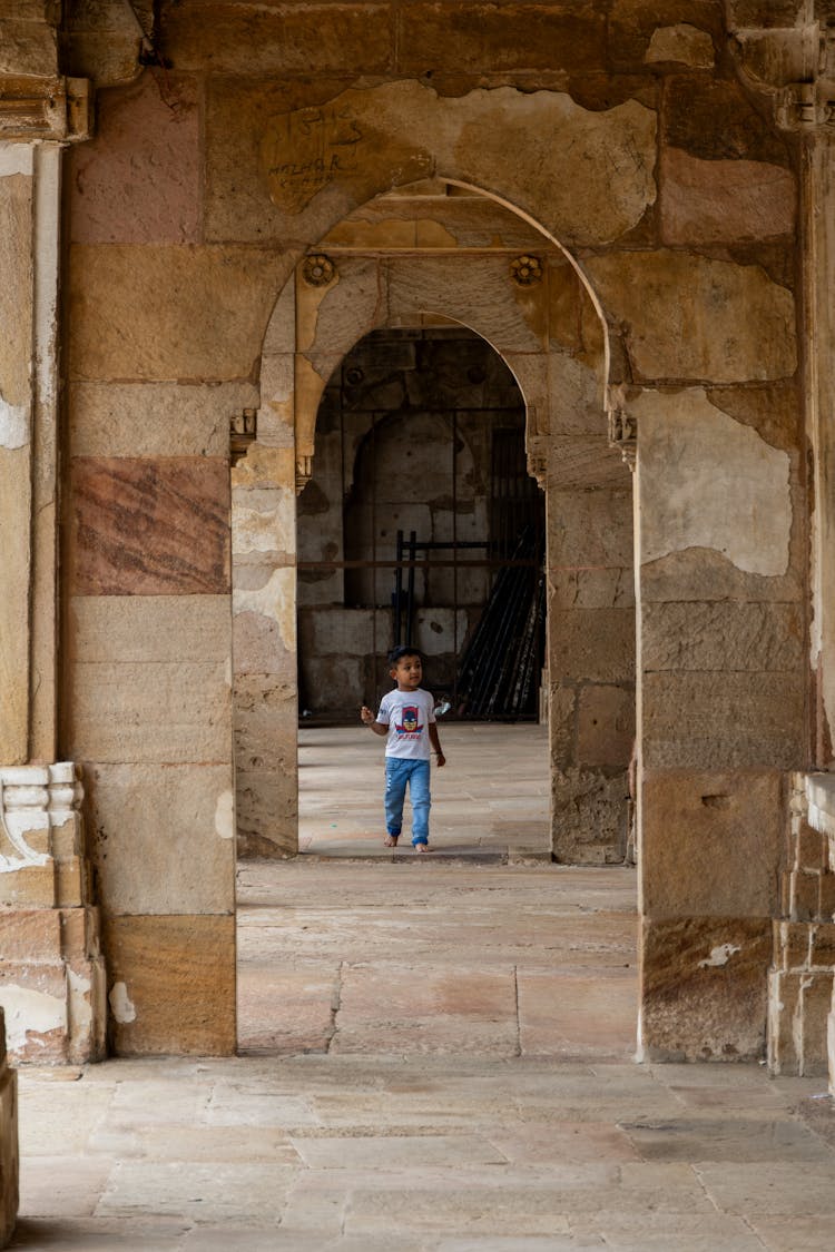 Boy Walking On Arcade Walkway