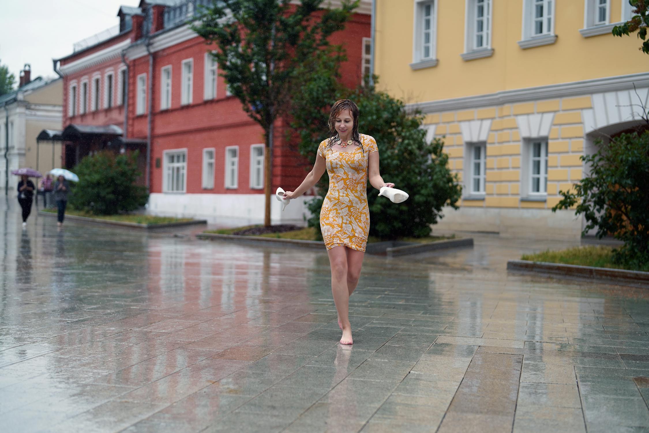 https://images.pexels.com/photos/17377271/pexels-photo-17377271/free-photo-of-woman-walking-barefoot-in-town-in-rain.jpeg?auto=compress&amp;cs=tinysrgb&amp;w=1260&amp;h=750&amp;dpr=2