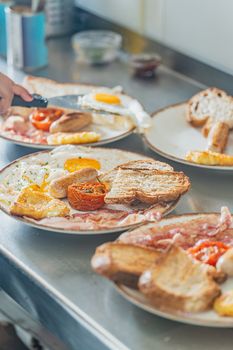 Savor a traditional English breakfast featuring eggs, bacon, sausages, and toast on a counter.
