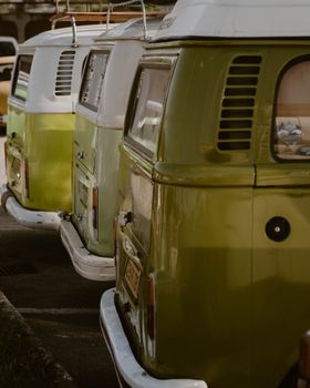 Line of vintage Volkswagen vans parked in a row, showcasing classic automotive design.