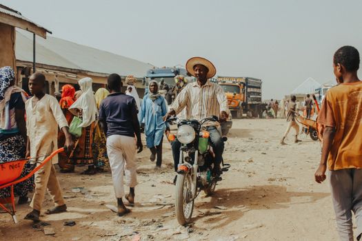 Man on Motorbike on Dirt Road in Village