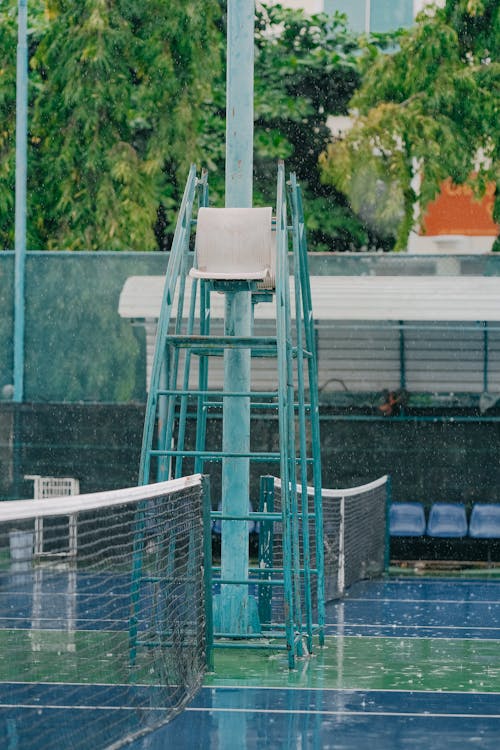 Empty Referee Tower Chair at Tennis Court in Rain