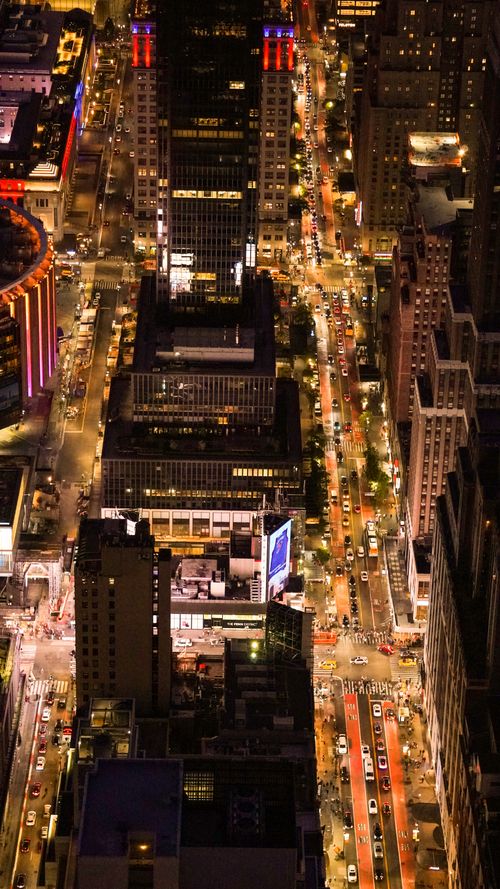 Free Stunning aerial view of illuminated Manhattan streets at night, showcasing New York City's vibrant urban life. Stock Photo