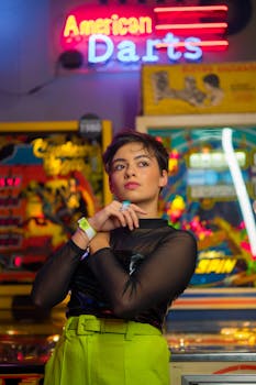 Stylish woman in neon arcade with vibrant lights and games around.