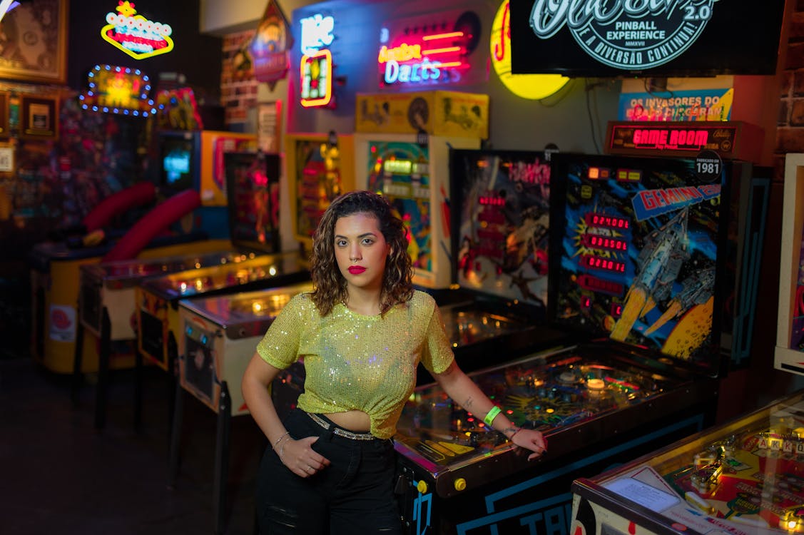 Free Woman Posing by Machines in Casino Stock Photo
