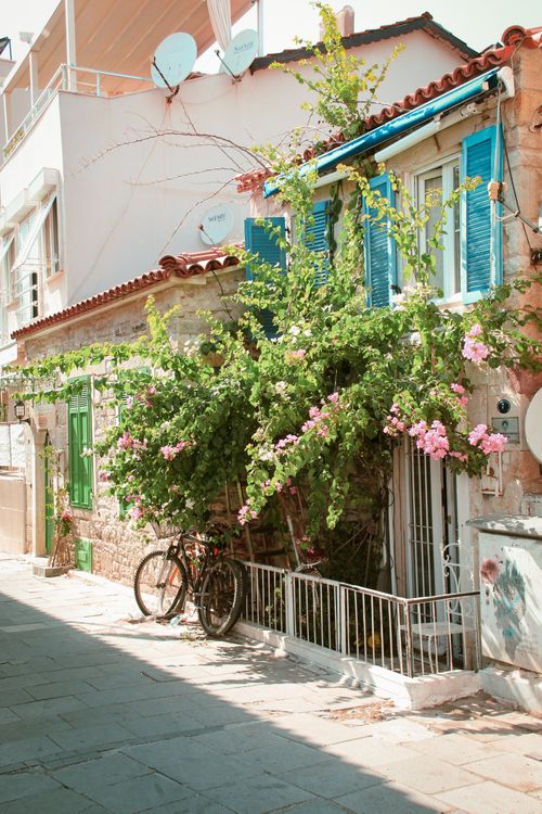 Free Discover a quaint alley in Türkiye adorned with vibrant blooms and rustic architecture. Stock Photo