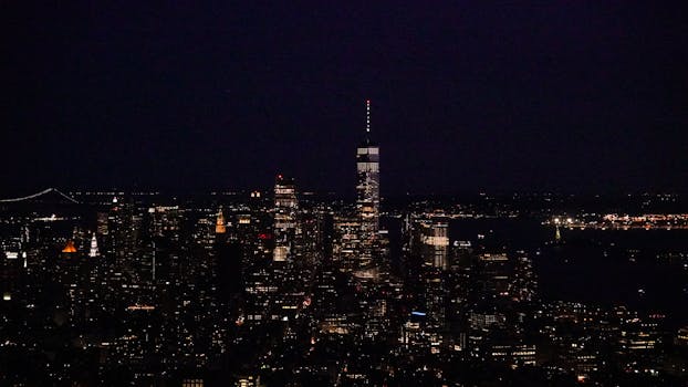 A stunning aerial view of New York City's skyline illuminated at night, showcasing iconic skyscrapers.
