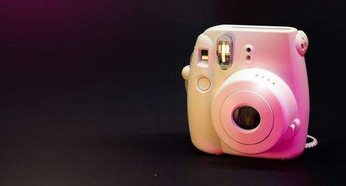 Free A white instant camera with a sleek design against a black backdrop. Stock Photo