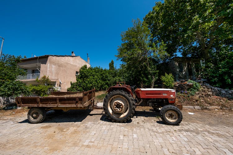 Vintage Tractor With Trailer In Village