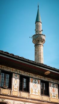 Vertical shot of a beautifully ornamented mosque and minaret under a clear sky in North Macedonia.