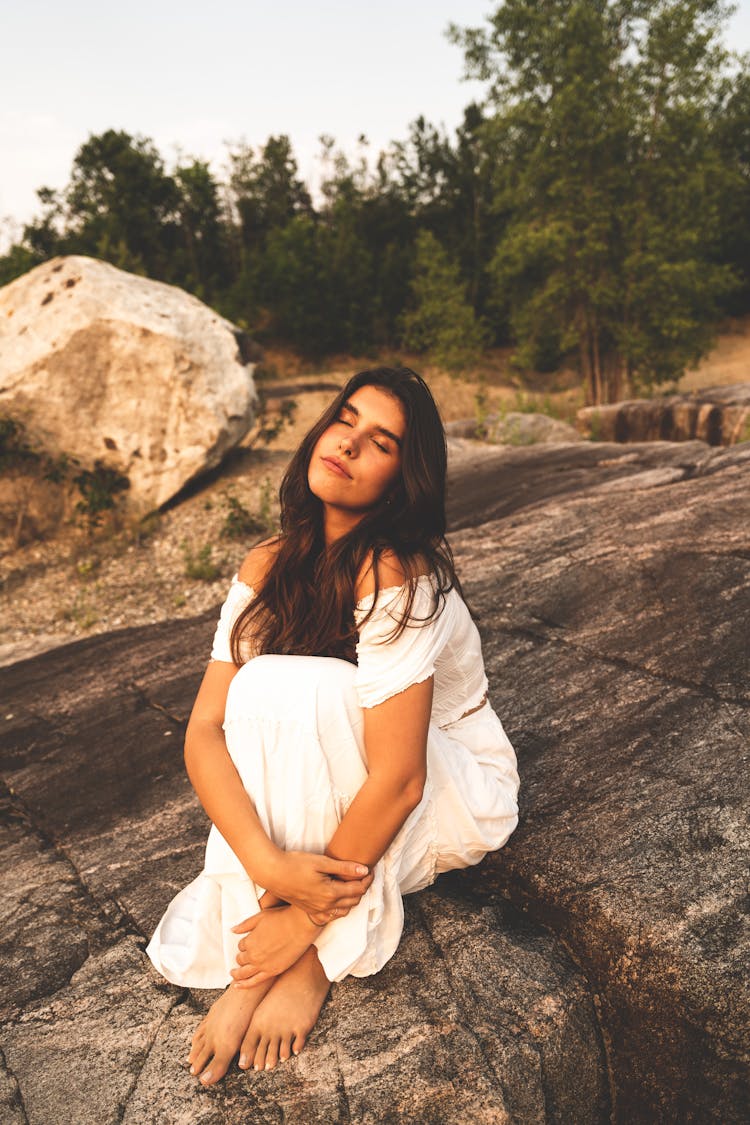 Woman In White Dress Sitting On Rock