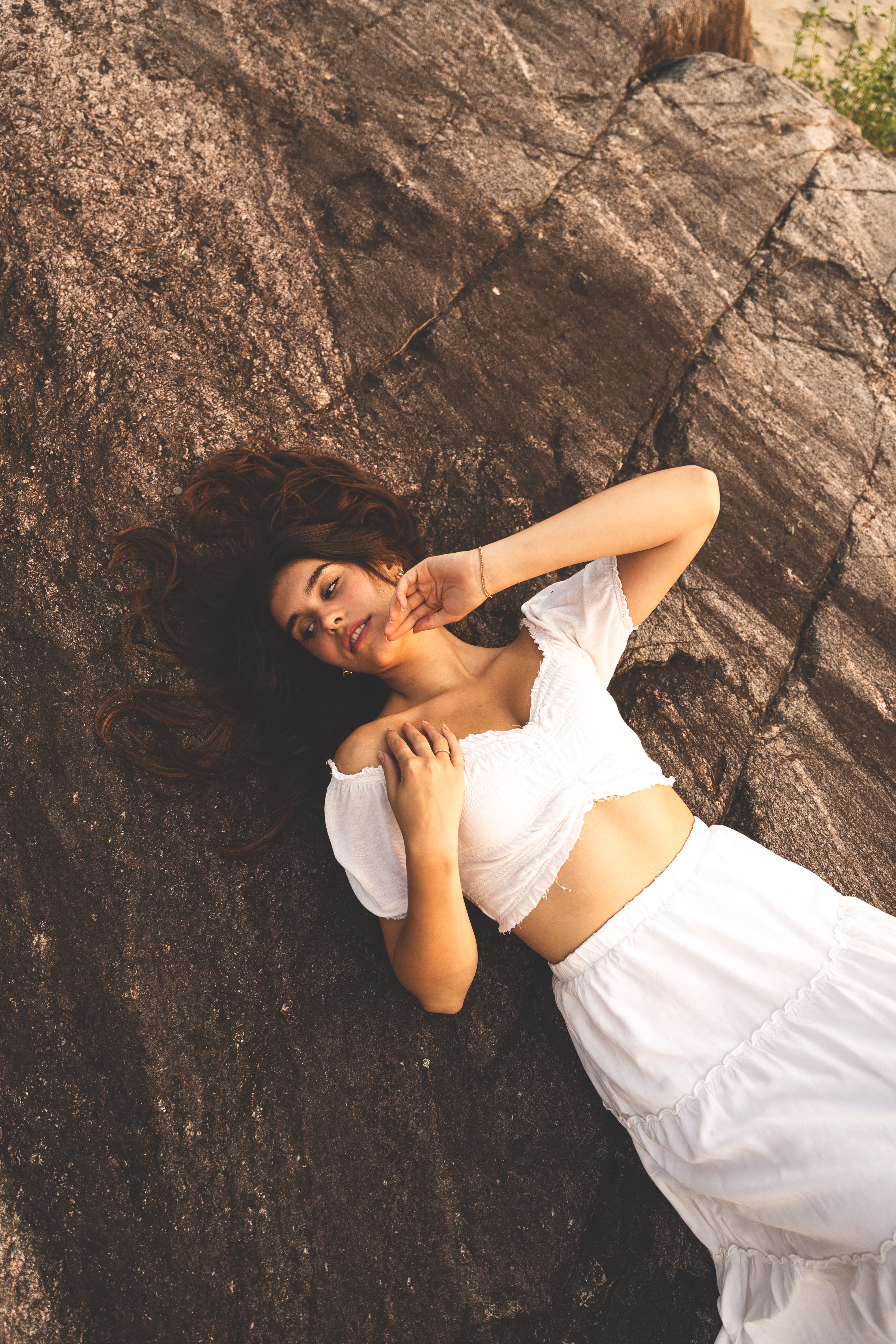 Woman in White Top and Skirt Lying Down on Rock · Free Stock Photo