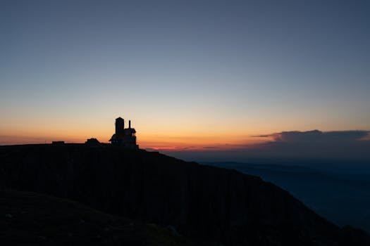Silhouette of a building against a vibrant sunset at Sniezne Kotly, Karkonosze Mountains, Poland.