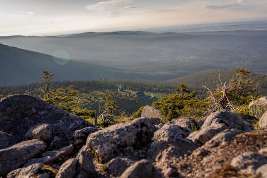 Breathtaking view of the Karkonosze Mountains at dusk showcasing rock formations and a vast valley.