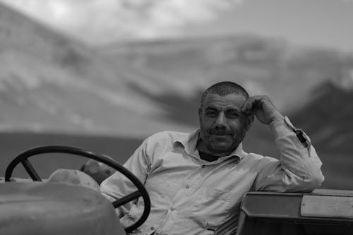 Man Sitting Behind a Steering Wheel of a Tractor 