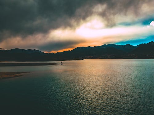 Dramatic Sky over a Lake and Mountains at Sunset 