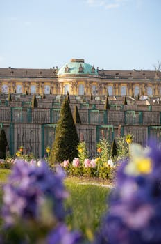 Bright summer day at Sanssouci Palace gardens, capturing vibrant flowers and Baroque architecture.
