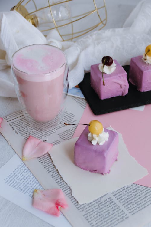 Pink Fruit Milkshake and Petit Four Cakes with Lilac Colored Glazing Decorated with Cherries