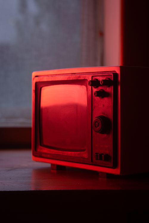 Free A vintage television set illuminated by red light, showcasing nostalgic technology indoors. Stock Photo