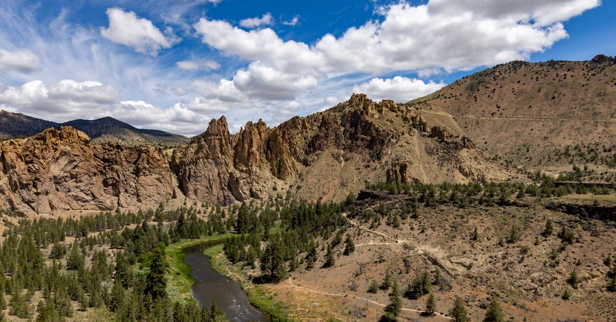 Explore the breathtaking rock formations and winding river of Smith Rock State Park on a sunny summer day.