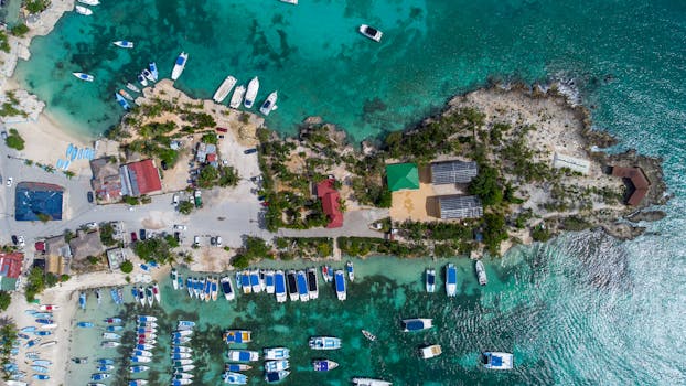 Stunning aerial view of boats docked in turquoise waters near a coastal area.