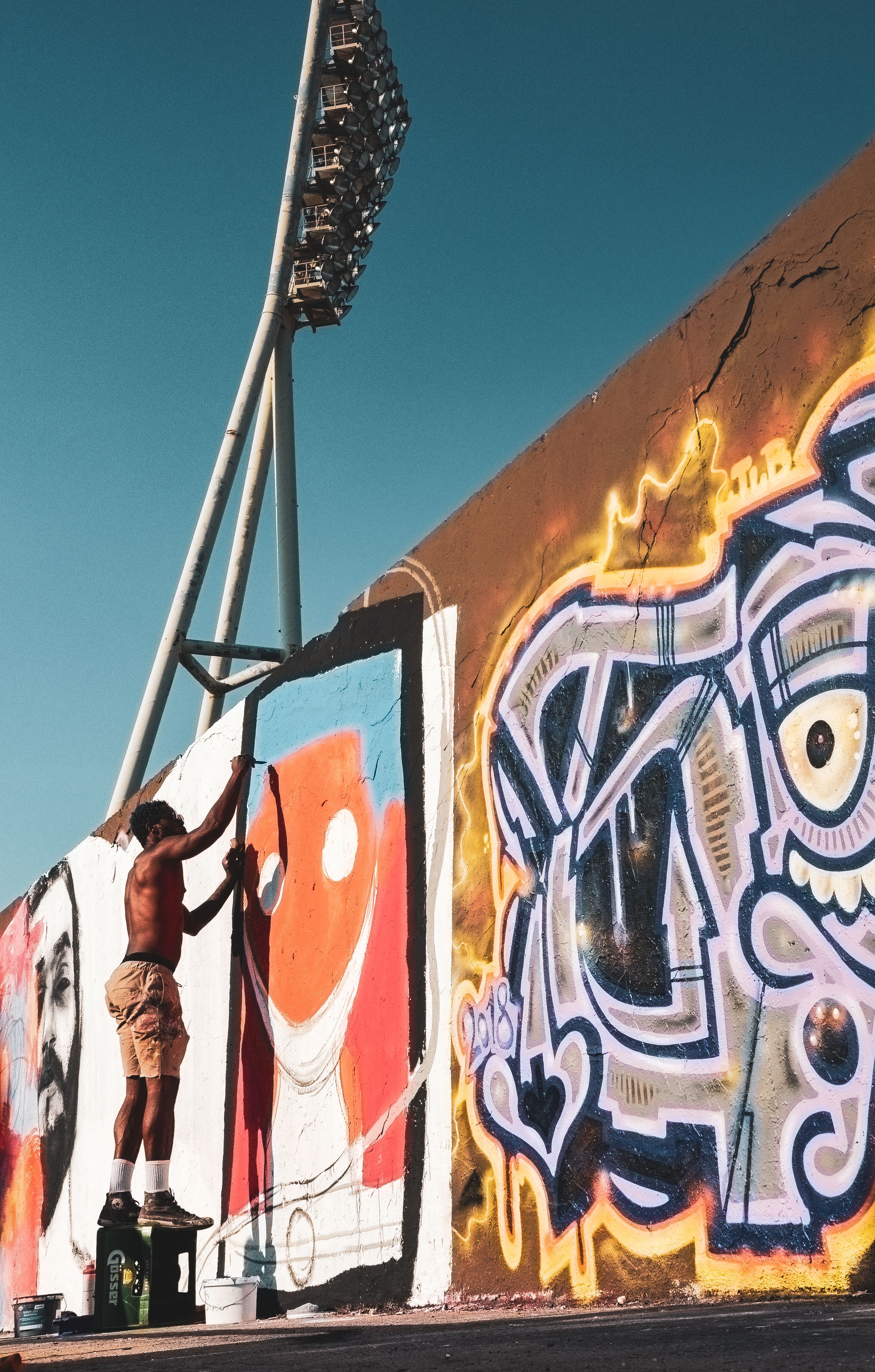 Artiste réalisant une fresque de street art sur un mur