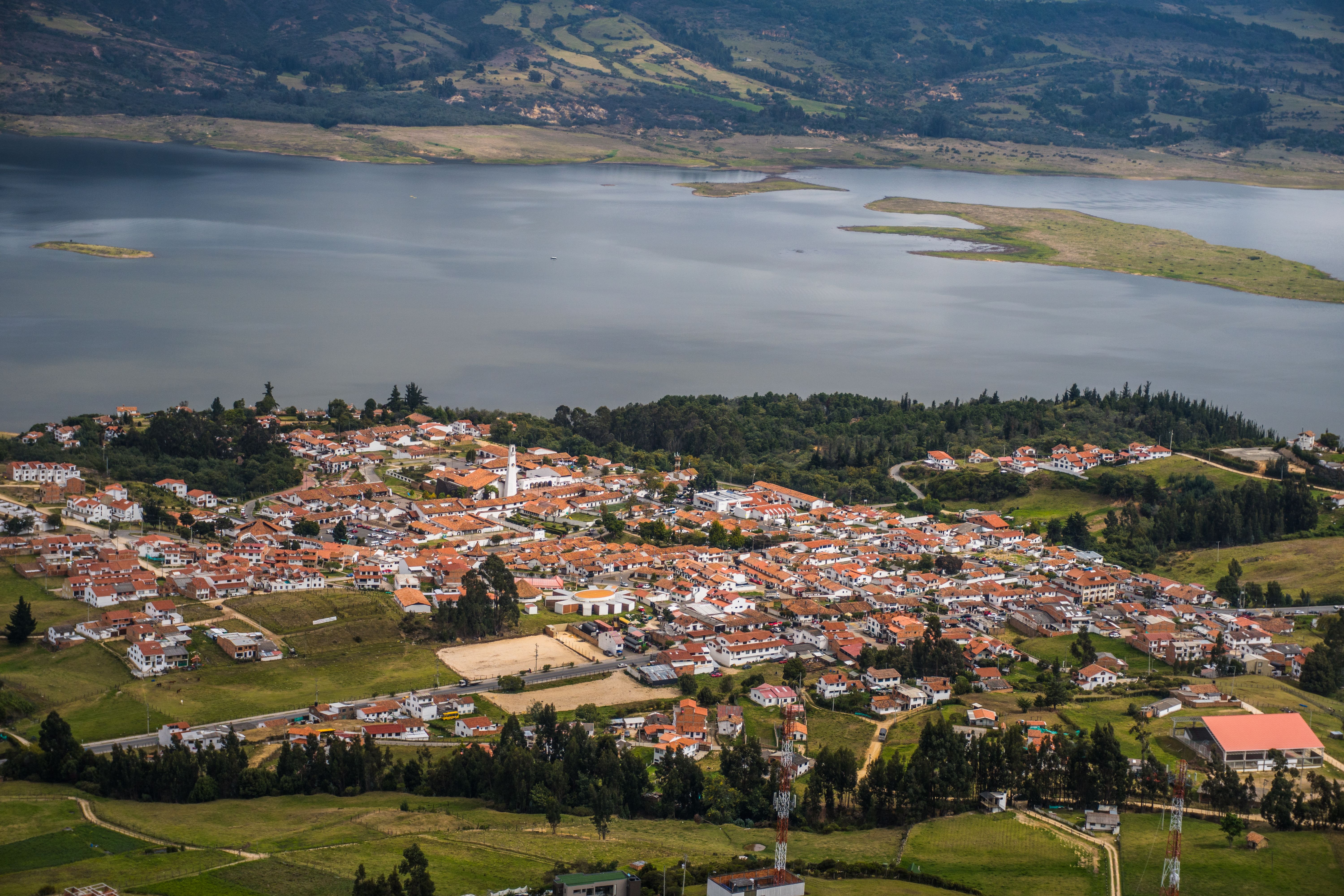 Stunning aerial view of Guatavita town and Tomine Reservoir in Colombia, showcasing a peaceful landscape.