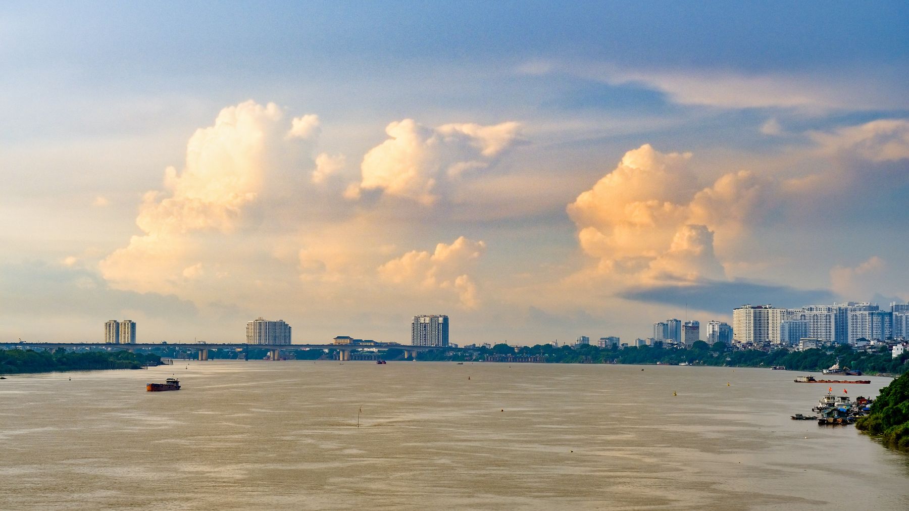 Beautiful view of Long Biên Bridge over the Red River in Hanoi, Vietnam with cityscape and cloudscape.