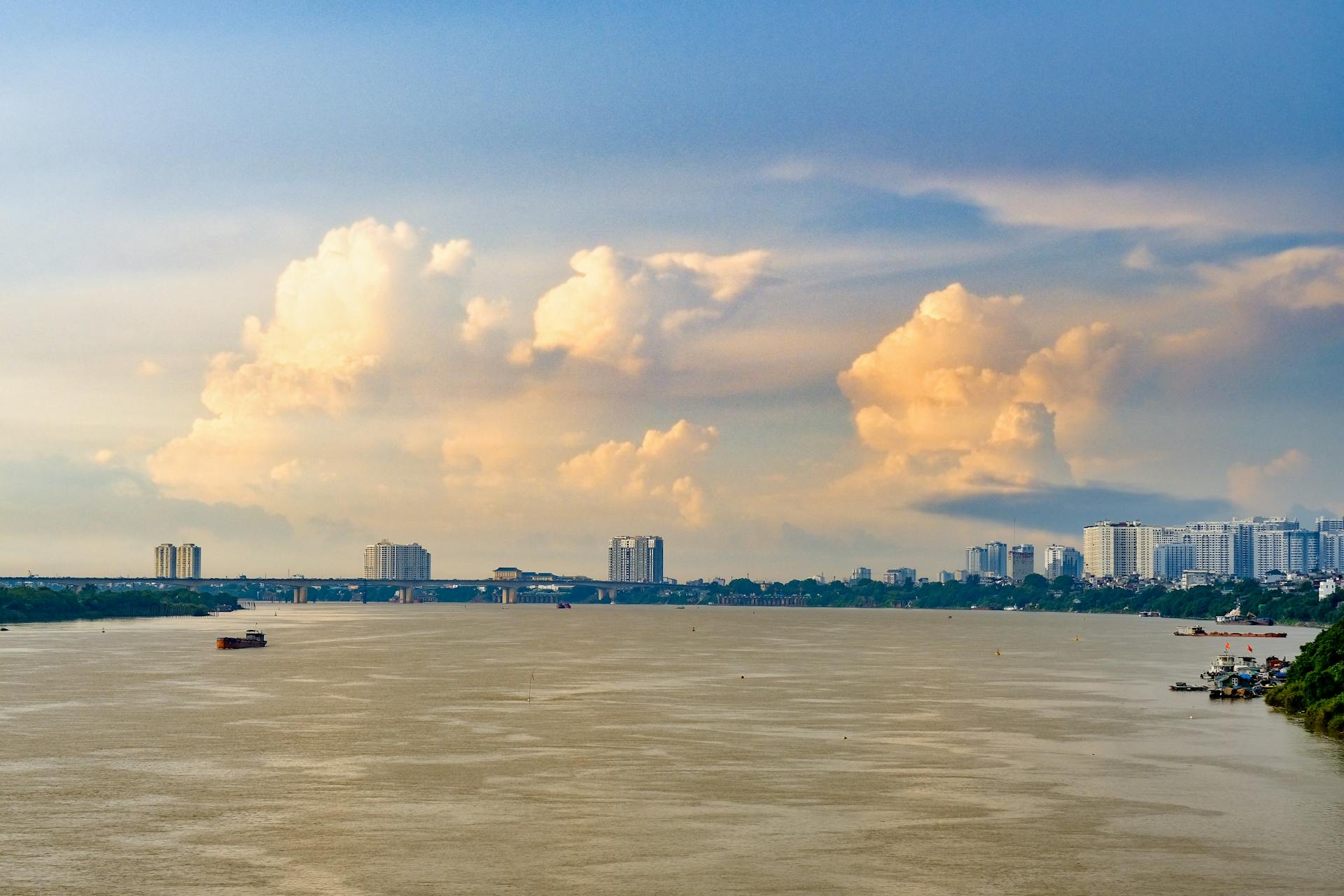 Beautiful view of Long Biên Bridge over the Red River in Hanoi, Vietnam with cityscape and cloudscape.
