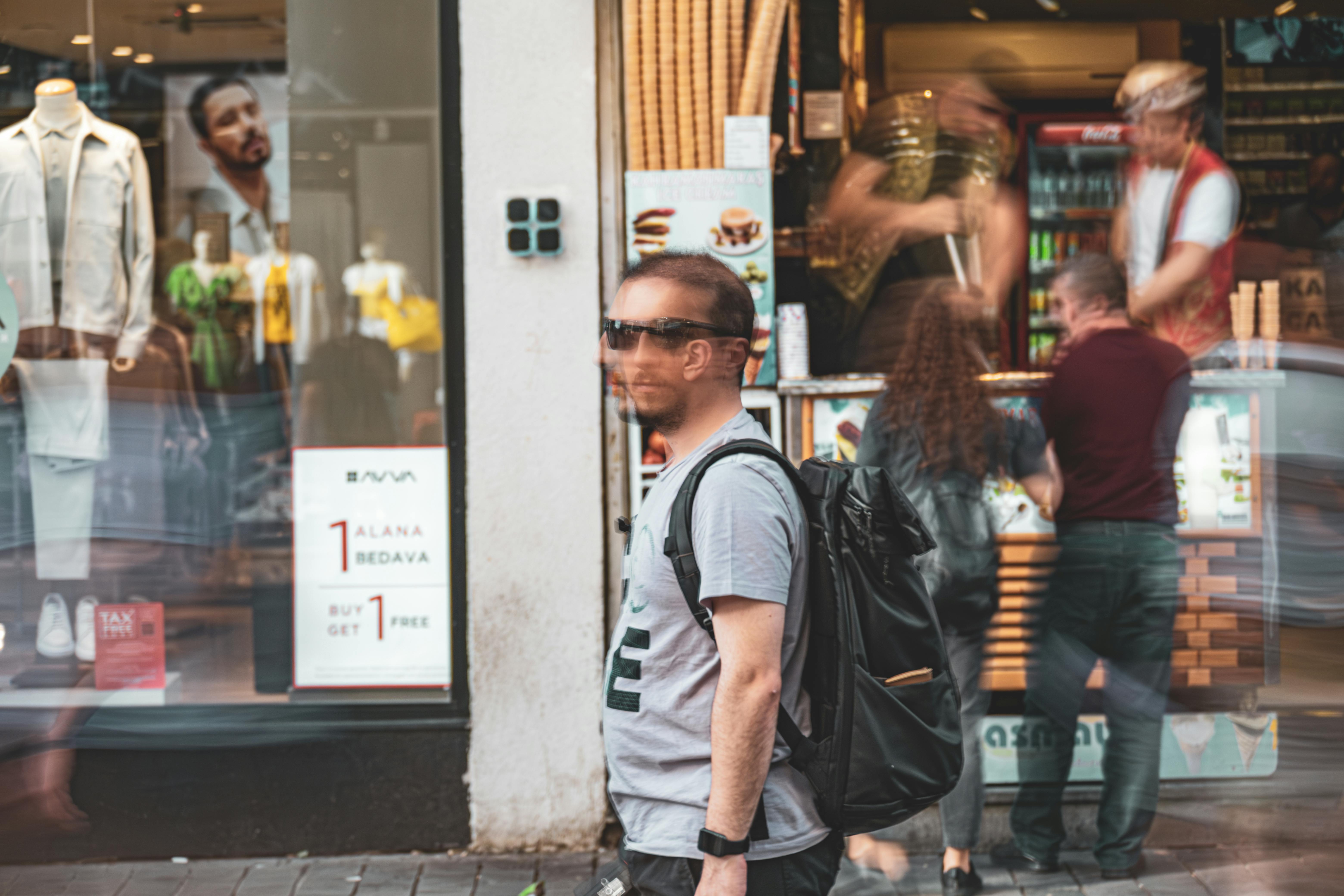 blurred man with backpack walking on sidewalk