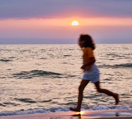 Girl Running along Sea at Dawn