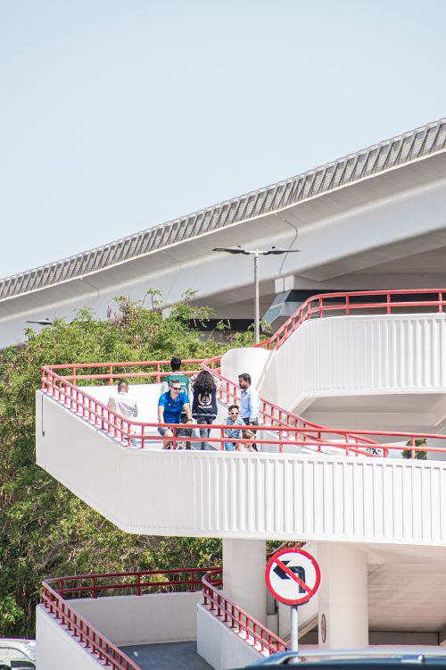 Free People walking on a modern urban footbridge in daylight. Stock Photo