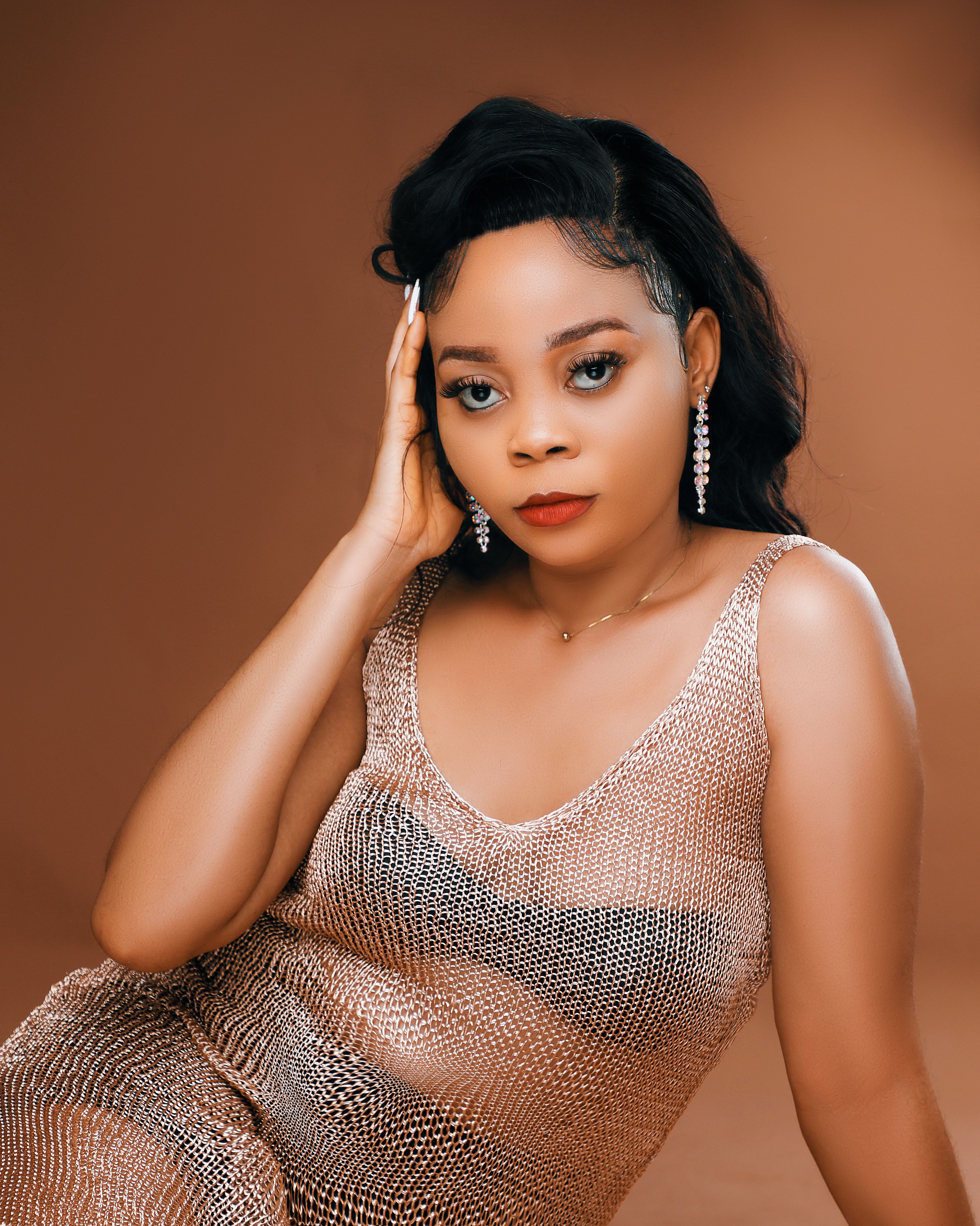 Stunning portrait of a black woman in elegant fashion with a rich brown background.