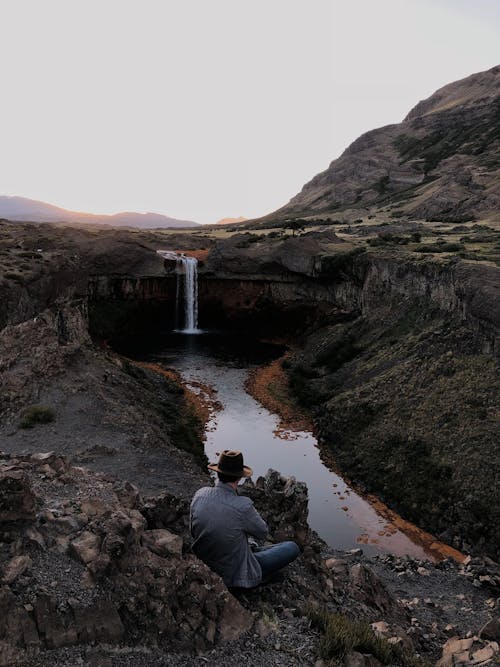 Man Sitting Near Waterfalls