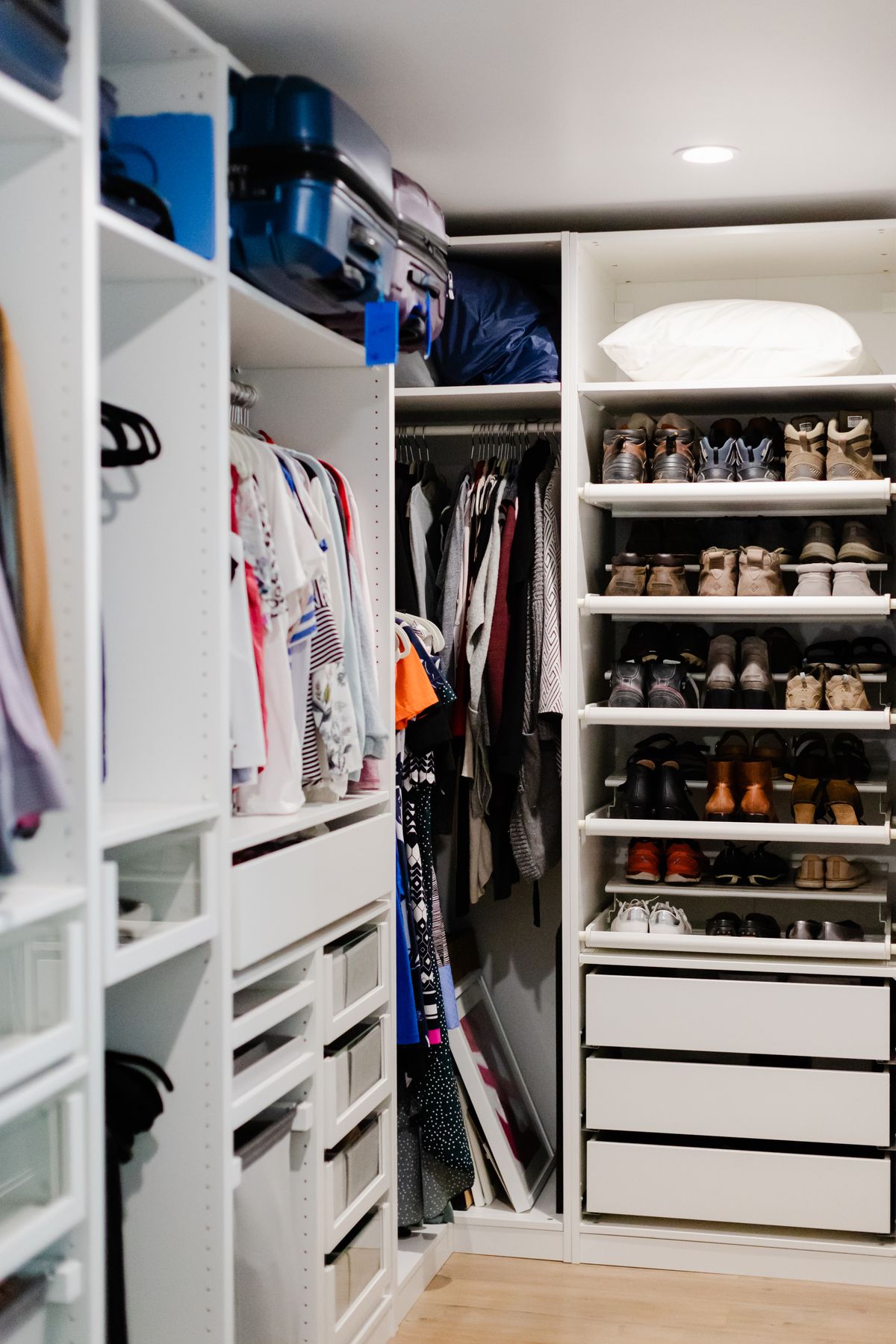 Well-organized walk-in closet with clothes on shelves