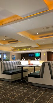 A modern box office interior featuring stylish seating and lighting, ideal for cinematic experiences.