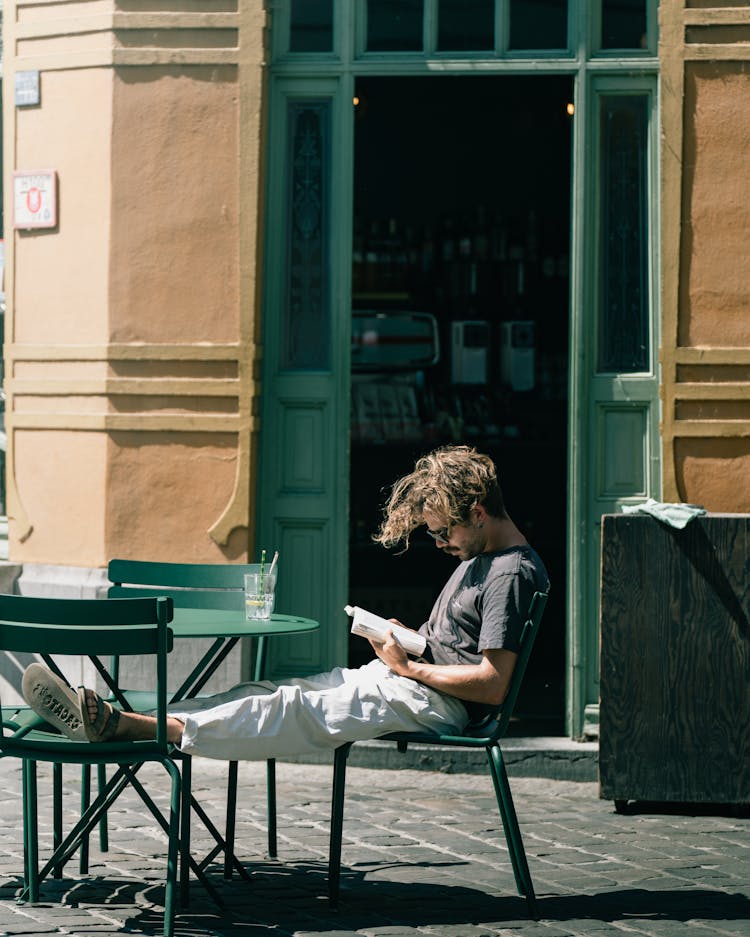 Man Sitting On Chairs And Reading