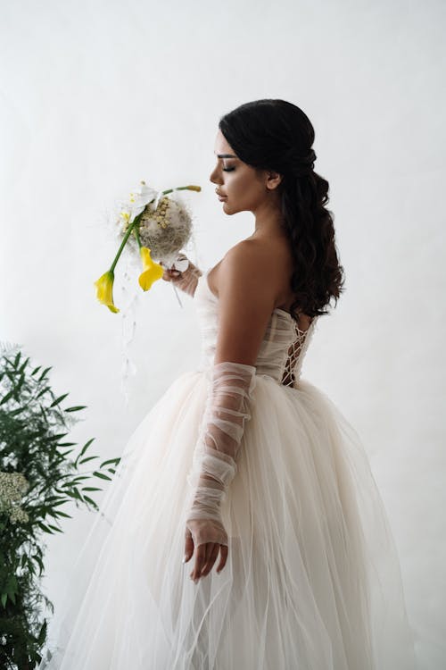 Portrait of a Bride Standing against a White Background