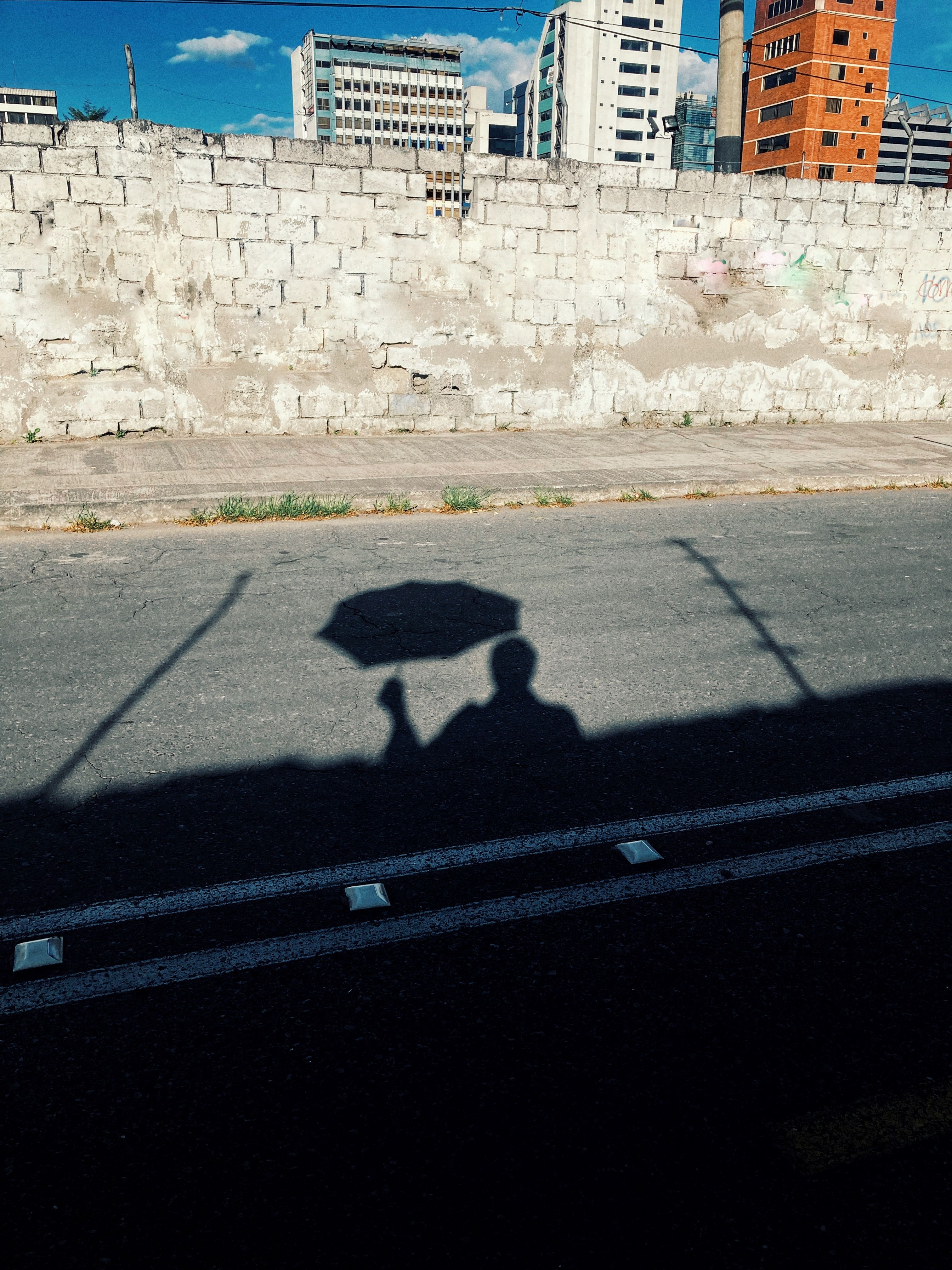 Shadow on the Street of a Man with an Umbrella · Free Stock Photo